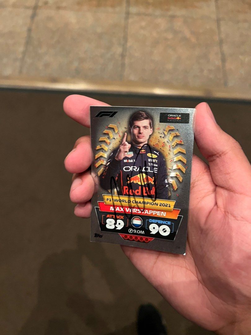 Max Verstappen Signed Topps Card (Category: Other Merchandise) located in Singapore. Submitted by jaisev_06 (Listing ID 1326202916, Image 1). Description: Signed by Max Verstappen after his first championship win in 2022. Got it signed when I met him. Can provide proof It is a Max Verstappen #296 World Champion 2022 Topps Turbo Attax F1 Foil Formula 1 Card Card is in good (8/10) condition.