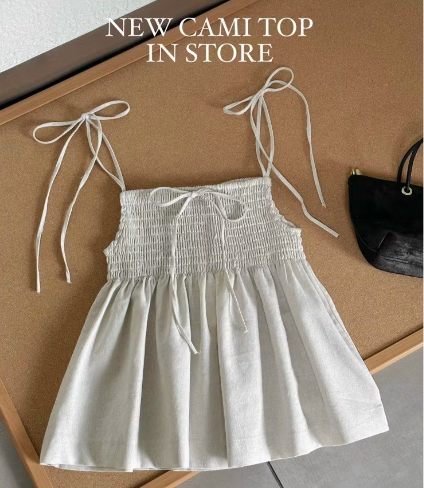 2 Strap Bow Tie Cami Smocked Top (Category: Sleeveless) located in Singapore. Submitted by strawberrisundae (Listing ID 1396302612, Image 2). Description: Brand new Size M Colour: pepper cream (most accurate to image 1) Linen Refer to last image for sizing chart Smartpac: $3 Meetup: west (can be discussed).