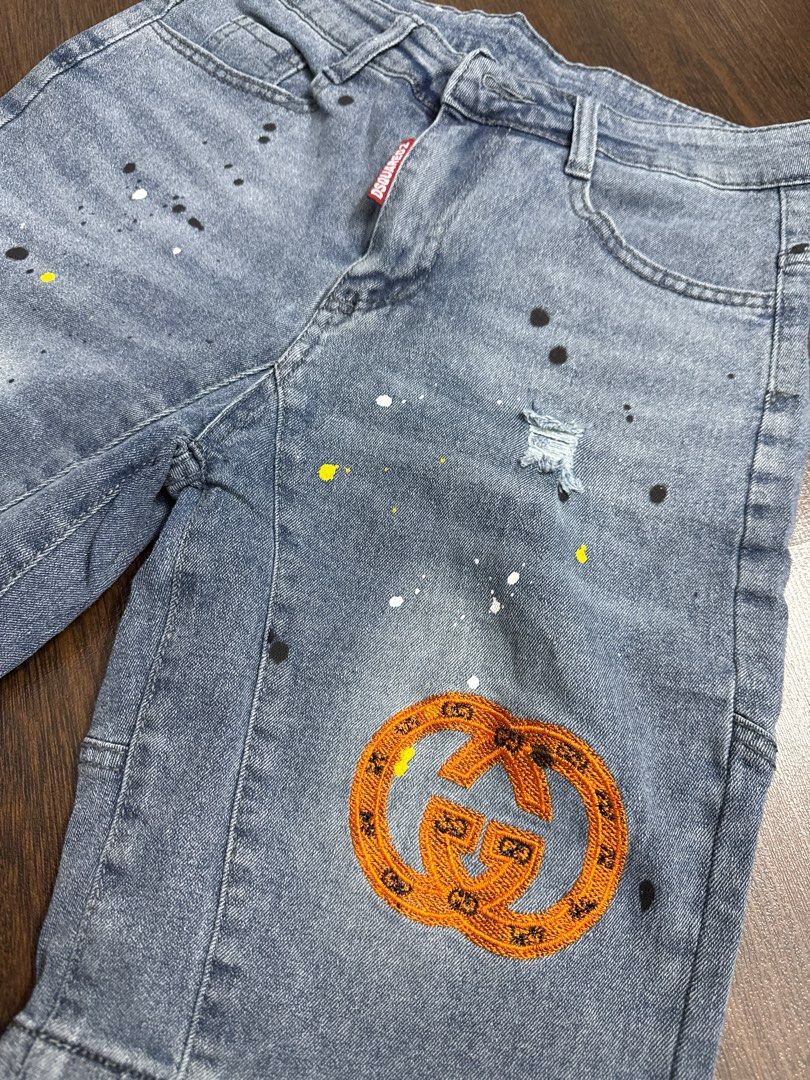 DSQUARED2 Gucci Denim Shorts (Category: Jeans & Leggings) located in Singapore. Submitted by unicorn49 (Listing ID 1391886610, Image 8). Description: - Stylish denim shorts - Features DSQUARED2 tag and Gucci logo patch - Distressed look with paint splatter details - In good condition - Ready to wear.