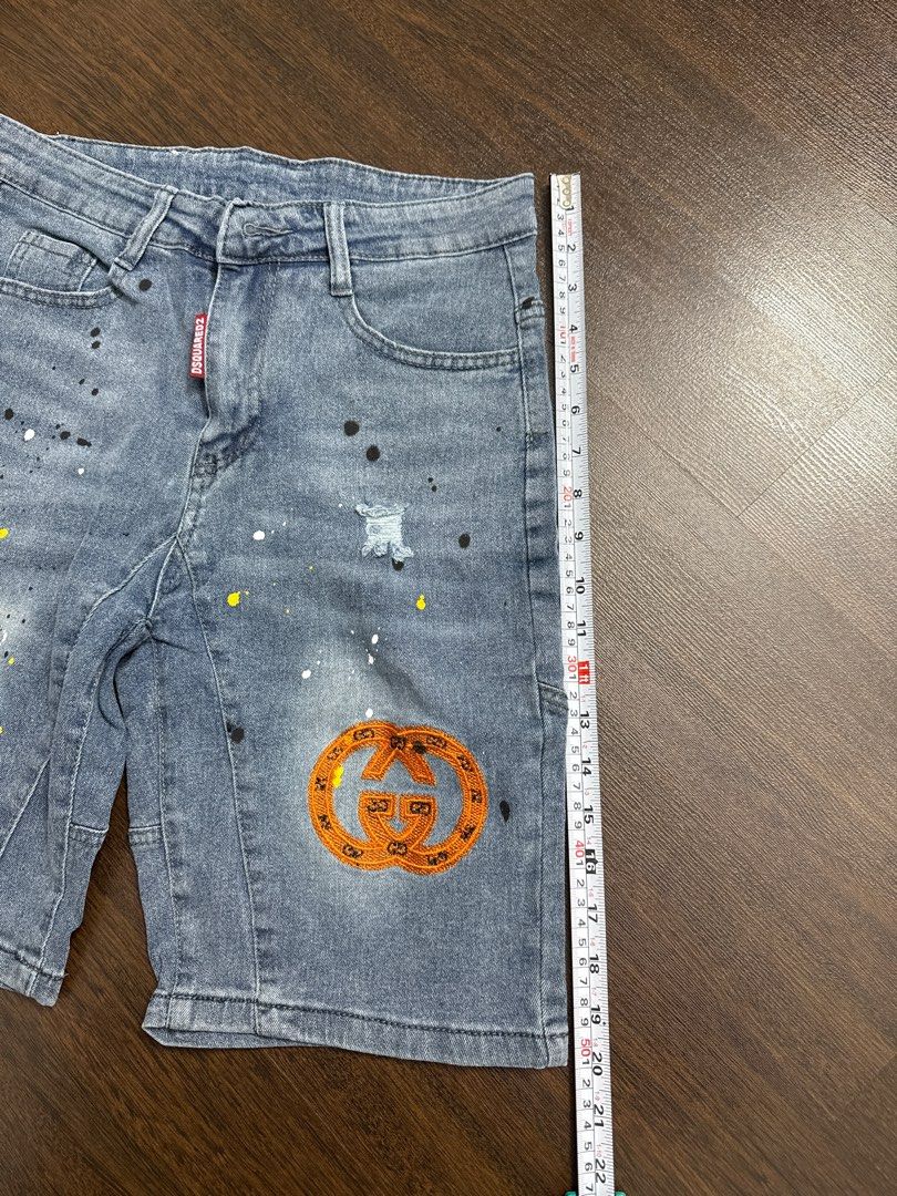DSQUARED2 Gucci Denim Shorts (Category: Jeans & Leggings) located in Singapore. Submitted by unicorn49 (Listing ID 1391886610, Image 3). Description: - Stylish denim shorts - Features DSQUARED2 tag and Gucci logo patch - Distressed look with paint splatter details - In good condition - Ready to wear.