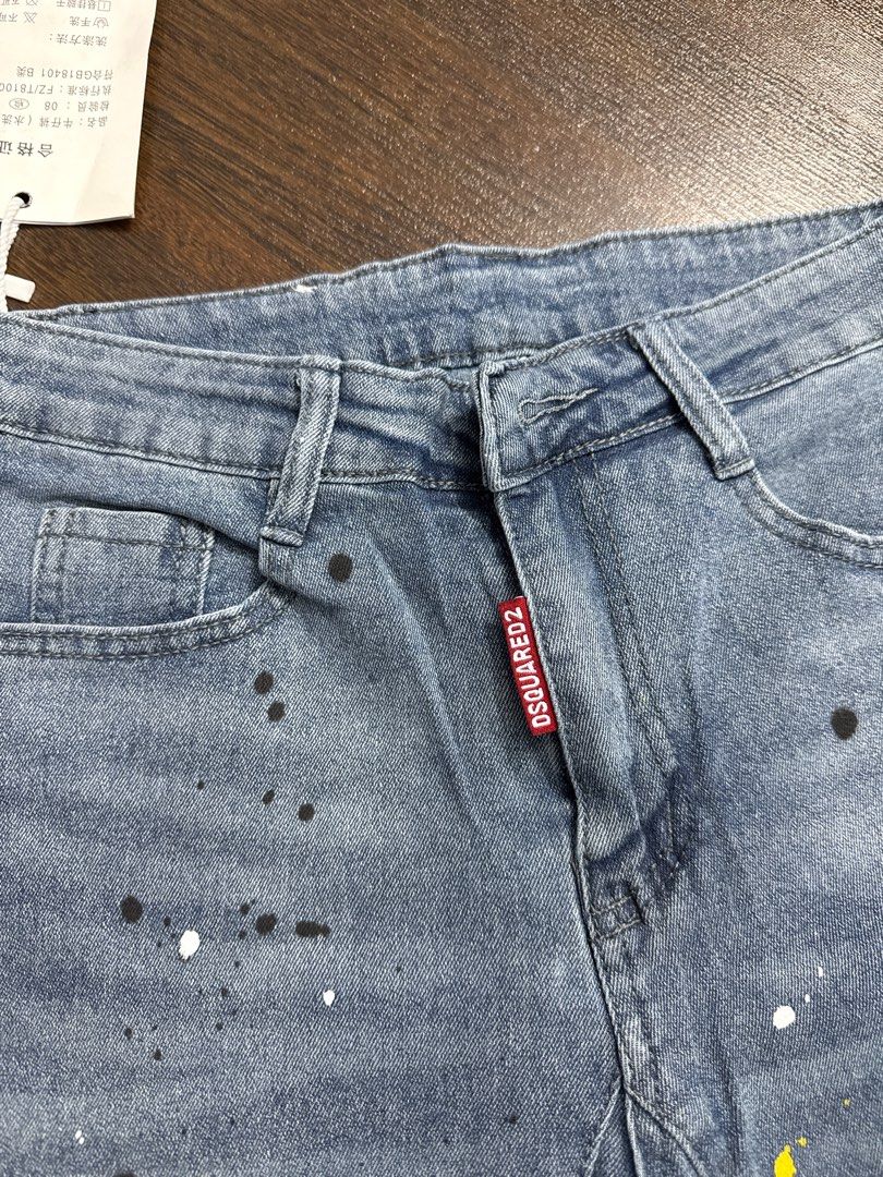 DSQUARED2 Gucci Denim Shorts (Category: Jeans & Leggings) located in Singapore. Submitted by unicorn49 (Listing ID 1391886610, Image 7). Description: - Stylish denim shorts - Features DSQUARED2 tag and Gucci logo patch - Distressed look with paint splatter details - In good condition - Ready to wear.