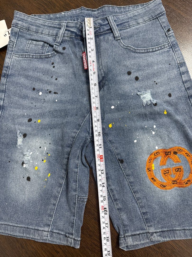 DSQUARED2 Gucci Denim Shorts (Category: Jeans & Leggings) located in Singapore. Submitted by unicorn49 (Listing ID 1391886610, Image 4). Description: - Stylish denim shorts - Features DSQUARED2 tag and Gucci logo patch - Distressed look with paint splatter details - In good condition - Ready to wear.