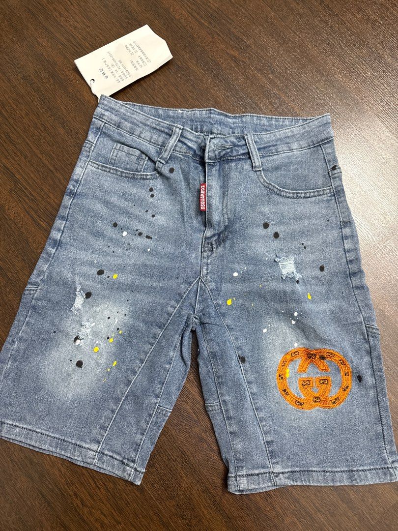 DSQUARED2 Gucci Denim Shorts (Category: Jeans & Leggings) located in Singapore. Submitted by unicorn49 (Listing ID 1391886610, Image 1). Description: - Stylish denim shorts - Features DSQUARED2 tag and Gucci logo patch - Distressed look with paint splatter details - In good condition - Ready to wear.