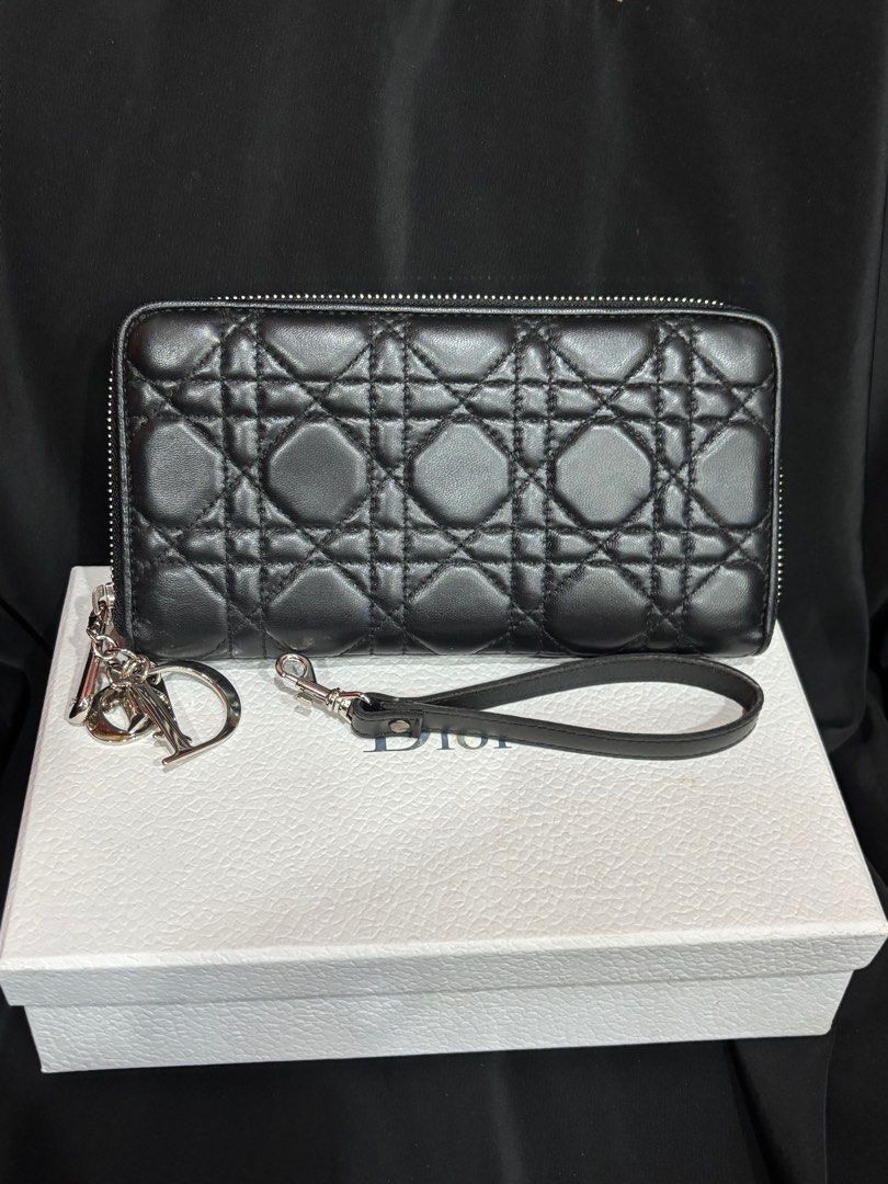 Preloved Athentic Christian Dior Black Cannage Quilted Lambskin Leather Lady Dior Zippy Wallet (Category: Bags & Wallets) located in Singapore. Submitted by villageplace (Listing ID 1413229682, Image 1). Description: This Dior wallet is a stunning addition to your collection. The wallet features the iconic Cannage quilted pattern in a lovely lambskin leather. The hanging DIOR charm letters (which are also removable) in silvertone hardware add som