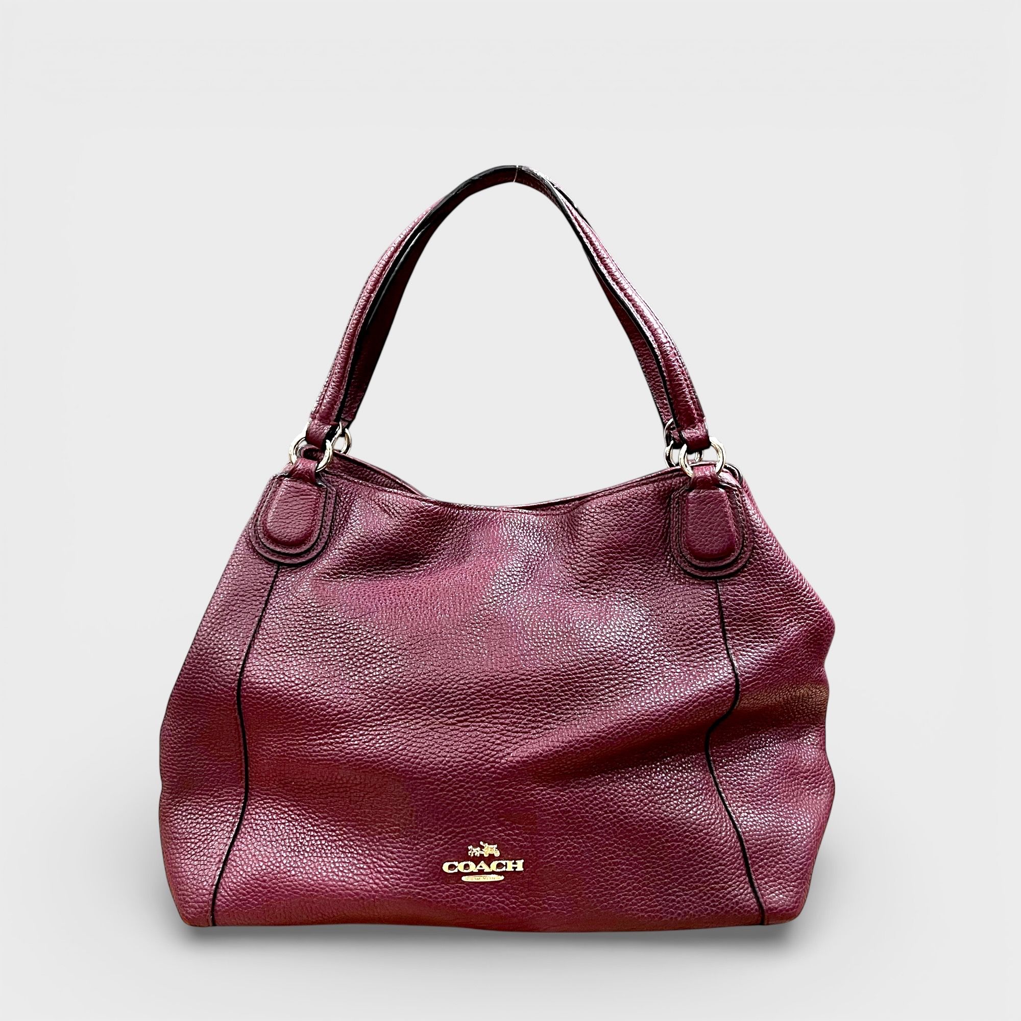 Coach Edie Shoulder Bag (Category: Bags & Wallets) located in Singapore. Submitted by thebarn.ccs (Listing ID 1430425028, Image 1). Description: Coach Edie shoulder bag in burgundy leather with gold‑tone hardware. No strap and no dust bag included. Height: 22 cm | 37 cm (with handle length) Width: 28 cm (widest) Depth: 10 cm SKU 75.
