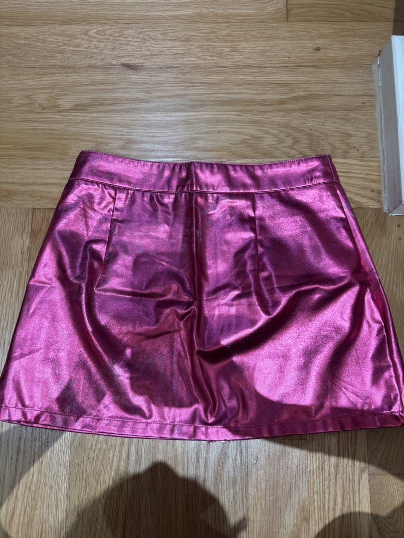 SHEIN Pink Metallic Mini Skirt M (Category: Skirts) located in Singapore. Submitted by sapphire_topaz (Listing ID 1436783968, Image 4). Description: - Pink metallic mini skirt - Front zipper - Two back pockets - Perfect for a bold look or night out - Some discoloration at the back but still ok, a bit of the worn look - Exchange with 3 box of tissue paper - Clementi MRT.