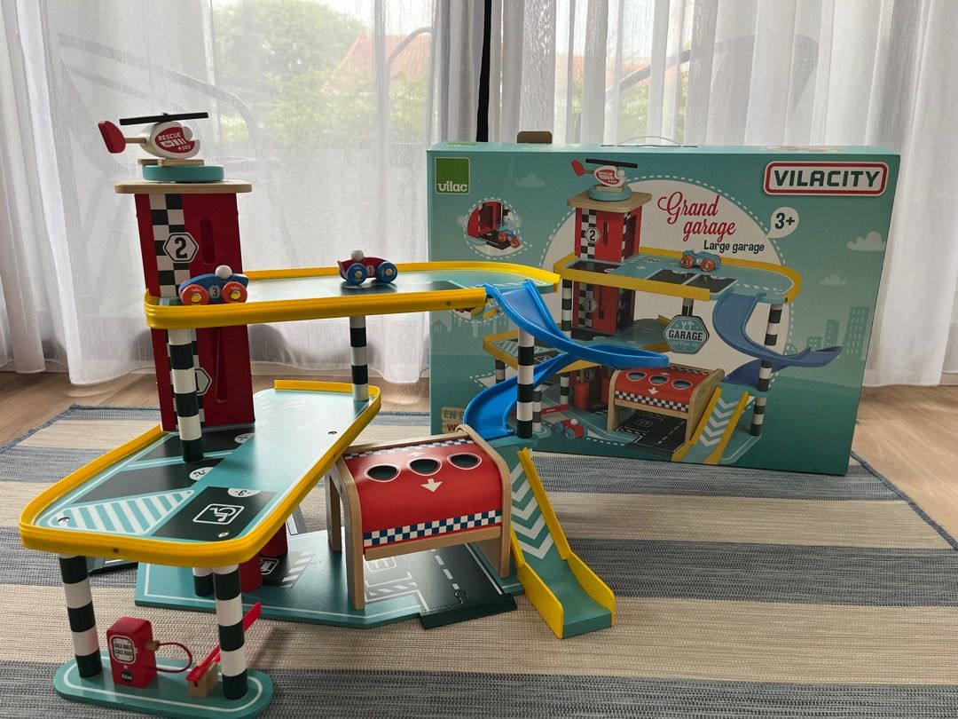 VILACITY Grand Garage Large Wooden Toy Playset with Cars & Helicopter (Category: Kids Toys) located in Singapore. Submitted by basile_505 (Listing ID 1441179120, Image 1). Description: - VILACITY Grand Garage wooden toy playset - Large size - Features ramps and multiple parking levels - Comes with a helicopter and toy cars - Encourages imaginative play - Original box included Payment by cash please.