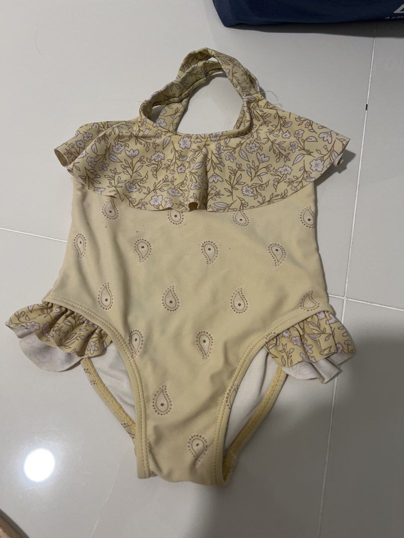 Cotton On Kids Yellow Paisley Floral Baby Girl Swimsuit Ruffle Halter Neck (Category: Babies & Kids Fashion) located in Singapore. Submitted by christellemey (Listing ID 1446116420, Image 1). Description: - Cute baby girl swimsuit - Yellow with paisley and floral print - Ruffled trim on legs and neckline - Halter neck tie - Perfect for beach days or pool fun - Great for summer adventures Tag: 3.