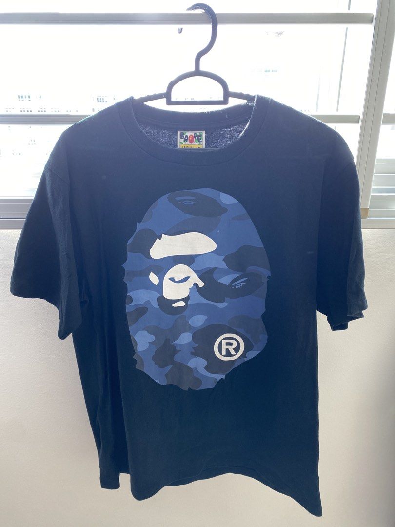 A Bathing Ape BAPE Tee (Category: Tshirts & Polo Shirts) located in Singapore. Submitted by joheun1616 (Listing ID 1446230581, Image 5). Description: 1 for $20, 2 for $35 BOTH wore 2 to 3 times only. - Black A Bathing Ape (BAPE) T-shirt x 2 - Size: Medium (M) - 1 x Front features iconic tiger camo with a zip graphic and back displays a tiger graphic and text - 1 x Front and Back features blue camo BAPE ape design - Small BAPE tag detail on the sl