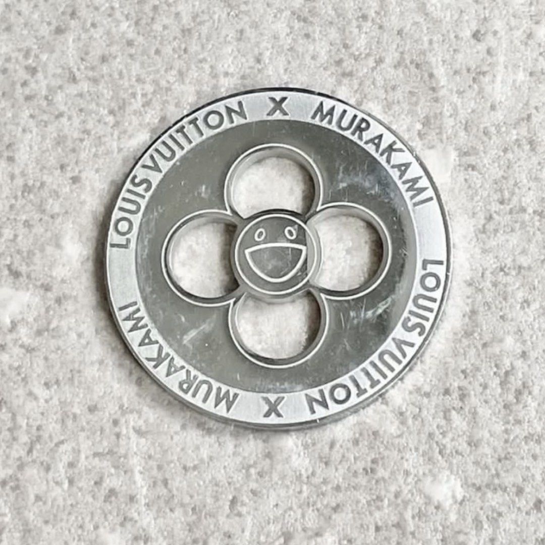 Louis Vuitton x Murakami Flower Charm Coin Token (Category: Accessories) located in Singapore. Submitted by sans57 (Listing ID 1442886872, Image 4). Description: Louis Vuitton x Murakami charm. Features the iconic smiling flower design Made of metal with engraved branding. Great for adding to bags or keychains. A collectible piece from the collaboration Rare! Only available for those who made purchase of LV Murakami items during limited pop-up pe