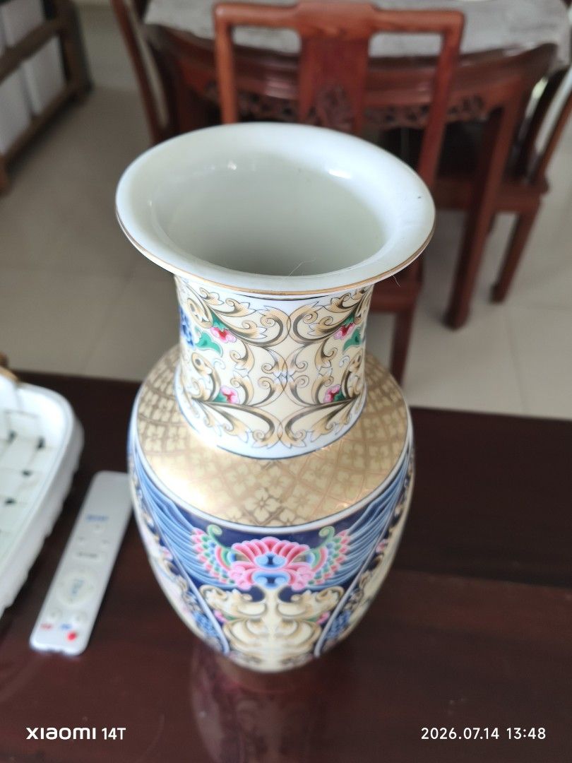 Vintage Porcelain Vase with Peacock and Floral Design (Category: Vases & Decorative Bowls) located in Singapore. Submitted by 823196 (Listing ID 1449586329, Image 2). Description: - Beautiful vintage porcelain vase - Intricate peacock and floral motifs in vibrant colors - Textured gold pattern on neck and base - Approx. 36cm height tall - Adds a classic touch to home decor - Ideal for flowers or as a decorative piece Widest width approx 15cm with