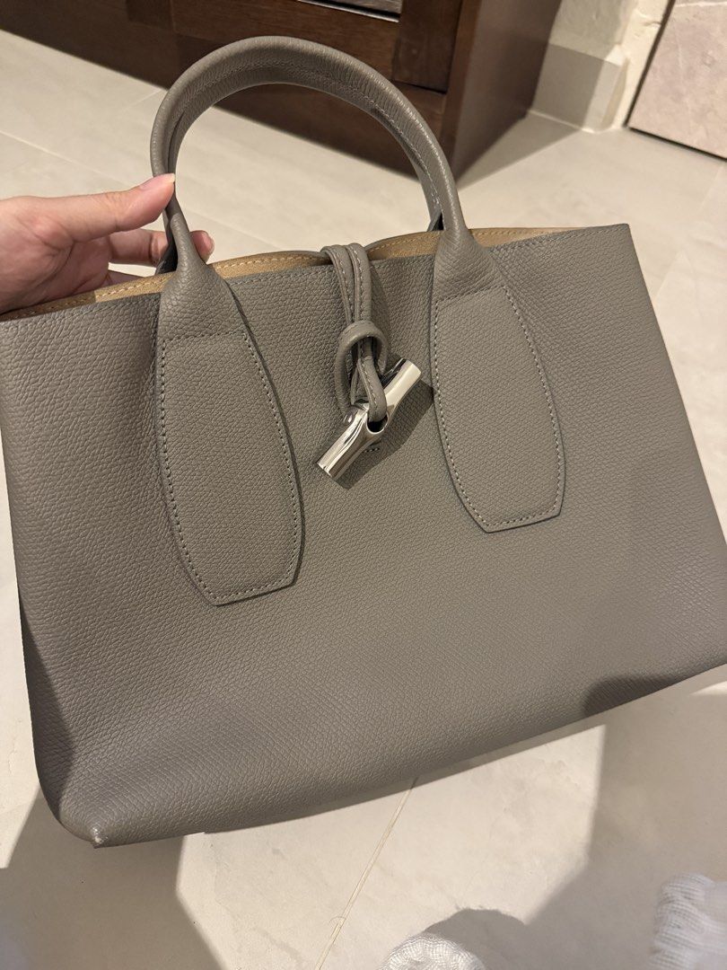 Longchamp Roseau Top Handle Bag M in Grey Leather (Category: Bags & Wallets) located in Singapore. Submitted by chikichiki96 (Listing ID 1449902233, Image 1). Description: - Brand: Longchamp - authentic 100% - Color: Grey - Dimension: 30 cm (Length) x 23.5 cm (Height) x 12 cm (Width) - Material: Leather - Features: Internal zip pocket, detachable strap - Includes: Dust bag - Ideal for: Everyday use, travel - Pick up: TPY/ Braddell mrt.