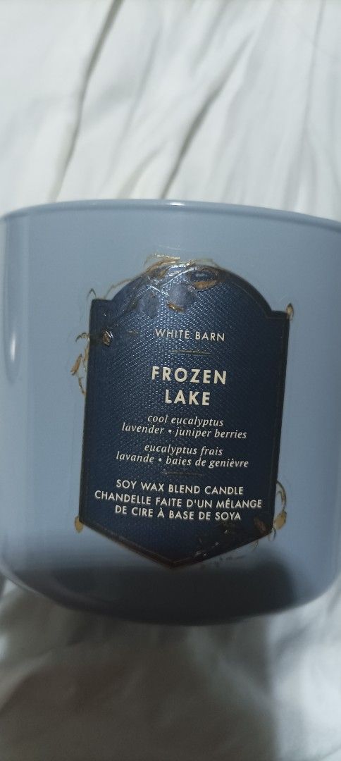 White Barn Frozen Lake Scented Candle (Category: Home Fragrance) located in Singapore. Submitted by clearancesaleess (Listing ID 1454040804, Image 1). Description: - White Barn 3-wick candle - Scent: Frozen Lake (eucalyptus, lavender, juniper berries) - Wax type: Soy blend - Condition: Label has wear and tear, lid has minor scratches - Burn time: Plenty of wax left lightly used for a while when hosting a guest almost full and like new.