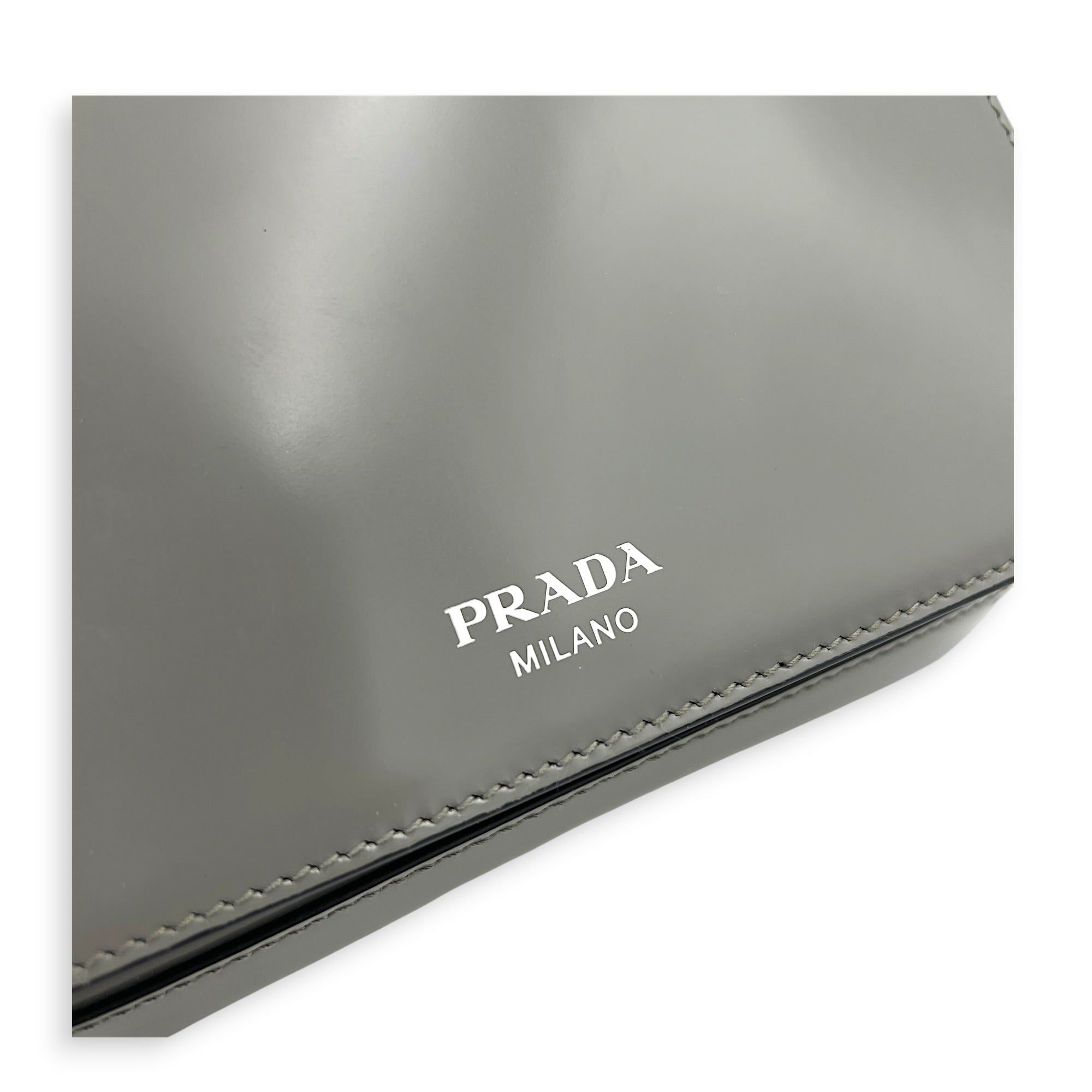 Prada Logo Crossbody Bag Grey in Patent Leather, Silver hardware (Category: Bags & Wallets) located in Singapore. Submitted by carousellluxury (Listing ID 1433497755, Image 7). Description: SKU C2604-011345AA Material Patent Leather Color Grey Hardware Silver Strap Included, detachable Dimension (L)18cm x (H)10cm x (W)7cm Accessories Dust Bag, Series 7/K Circa Est NA Microchipped FALSE Condition - Surface: In very good condition overall - Bottom 